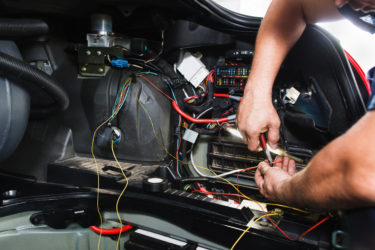 Mecanic cuts electrical wire in car